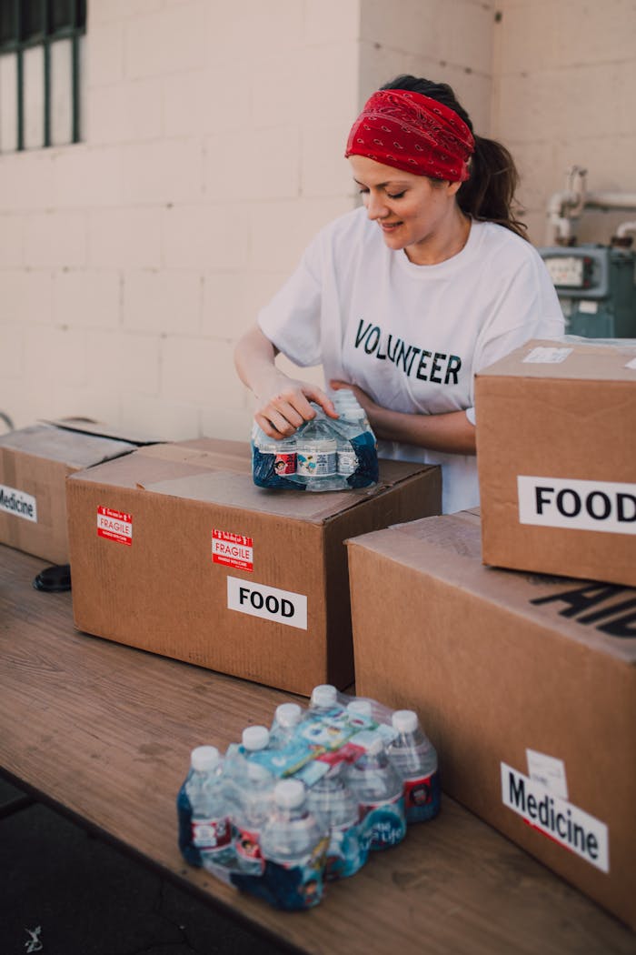 Mastering the First Impression: Your intriguing post title goes here Volunteer packing food and water for charity at an outdoor event, emphasizing community support.
